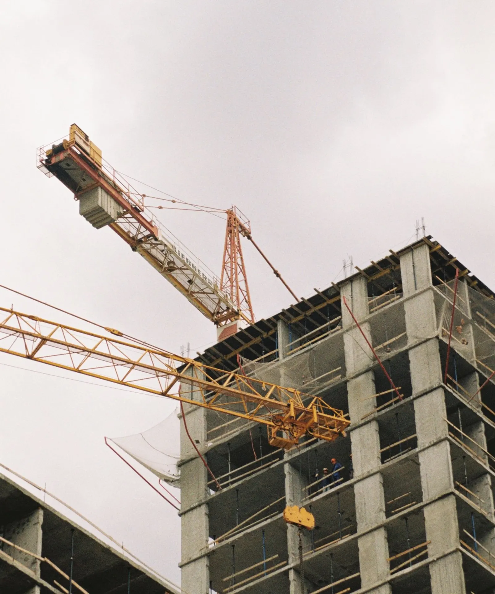 Concrete building structure and cranes during construction